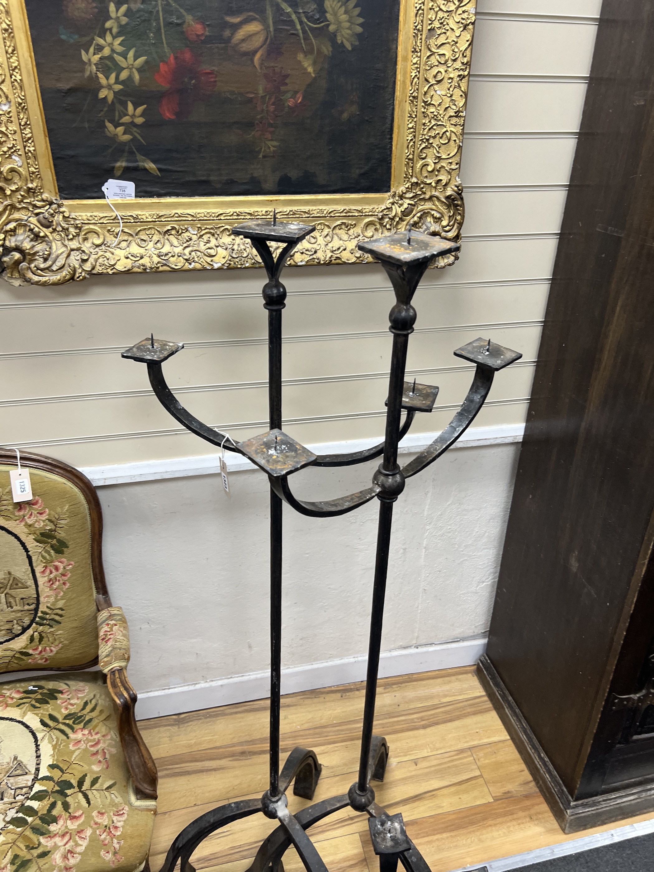 A pair of wrought iron three branch tripod pricket candlestands, height 146cm together with a matching four branch pricket candle holder